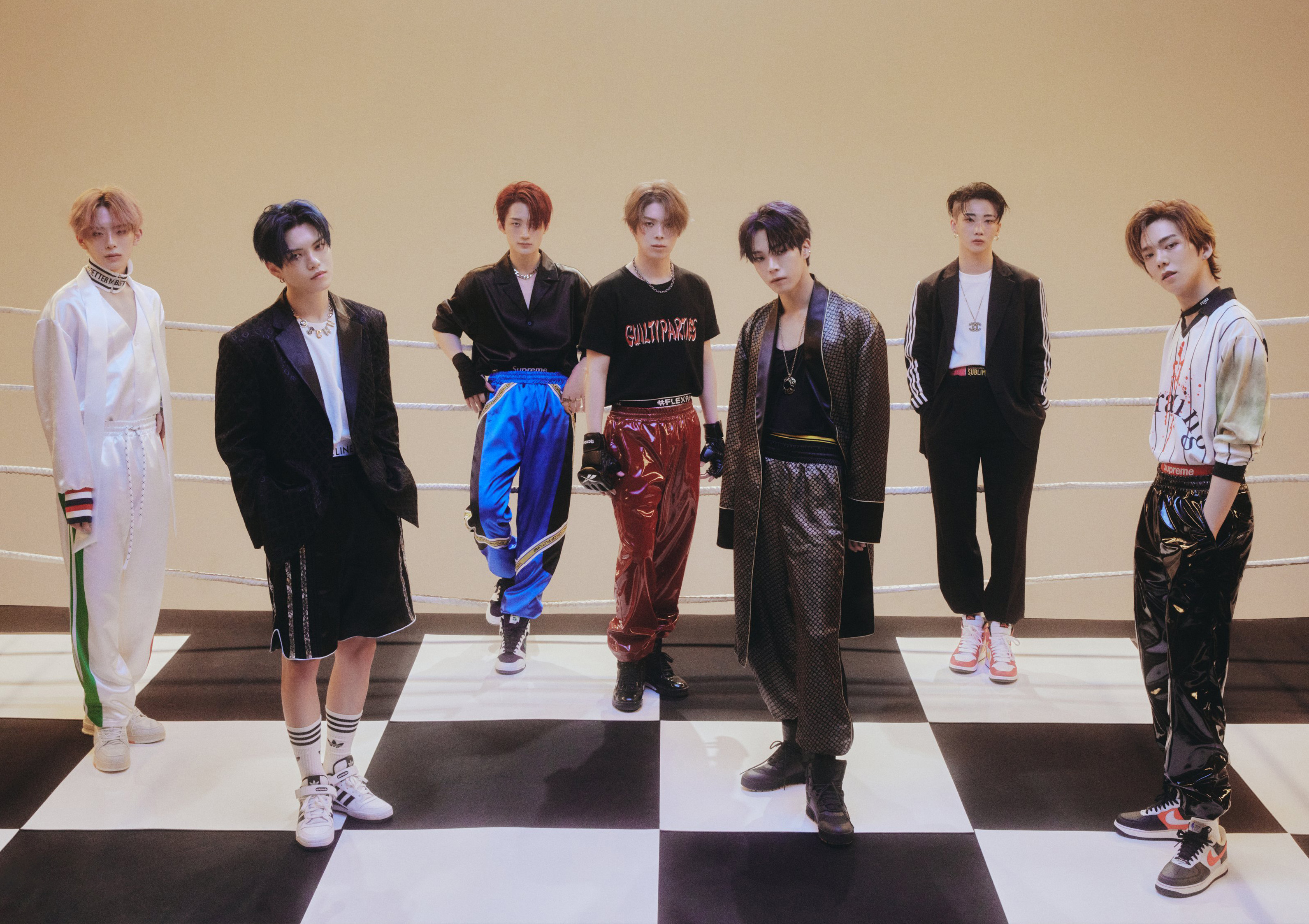 VERIVERY posando para foto em chão quadriculado preto e branco.
