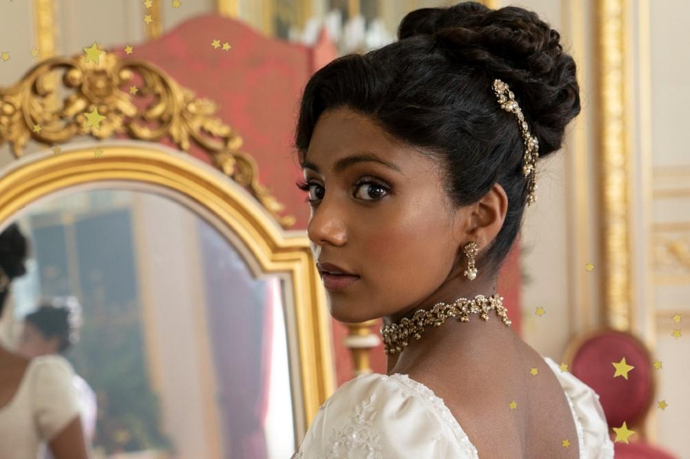 Imagem mostra Charithra Chandran caracterizada como Edwina Sharma usando joias de ouro e vestido de noiva bordado na segunda temporada de Bridgerton.
