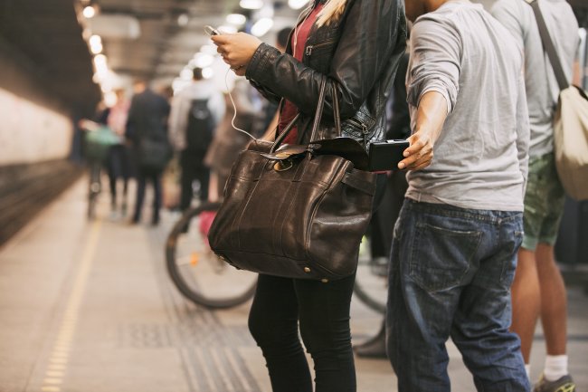 Mulher tendo o celular furtado de dentro da bolsa no metrô
