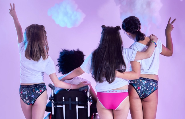 Quatro meninas de costas usando a calcinha menstrual da coleção da CAPRICHO com a Korui