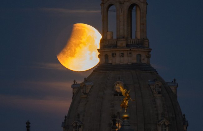 Lua de Sangue surgindo atrás da torre de uma igreja