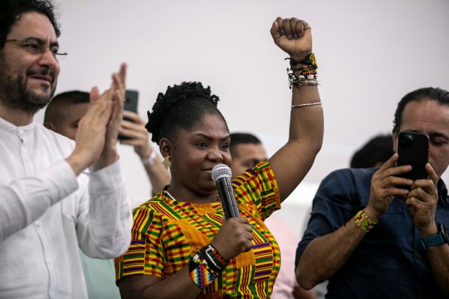 Imagem da Francia Márquez, primeira mulher negra eleita vice-presidente da Colômbia. Ela segura o microfone com uma mão e ergue o punho com a outra