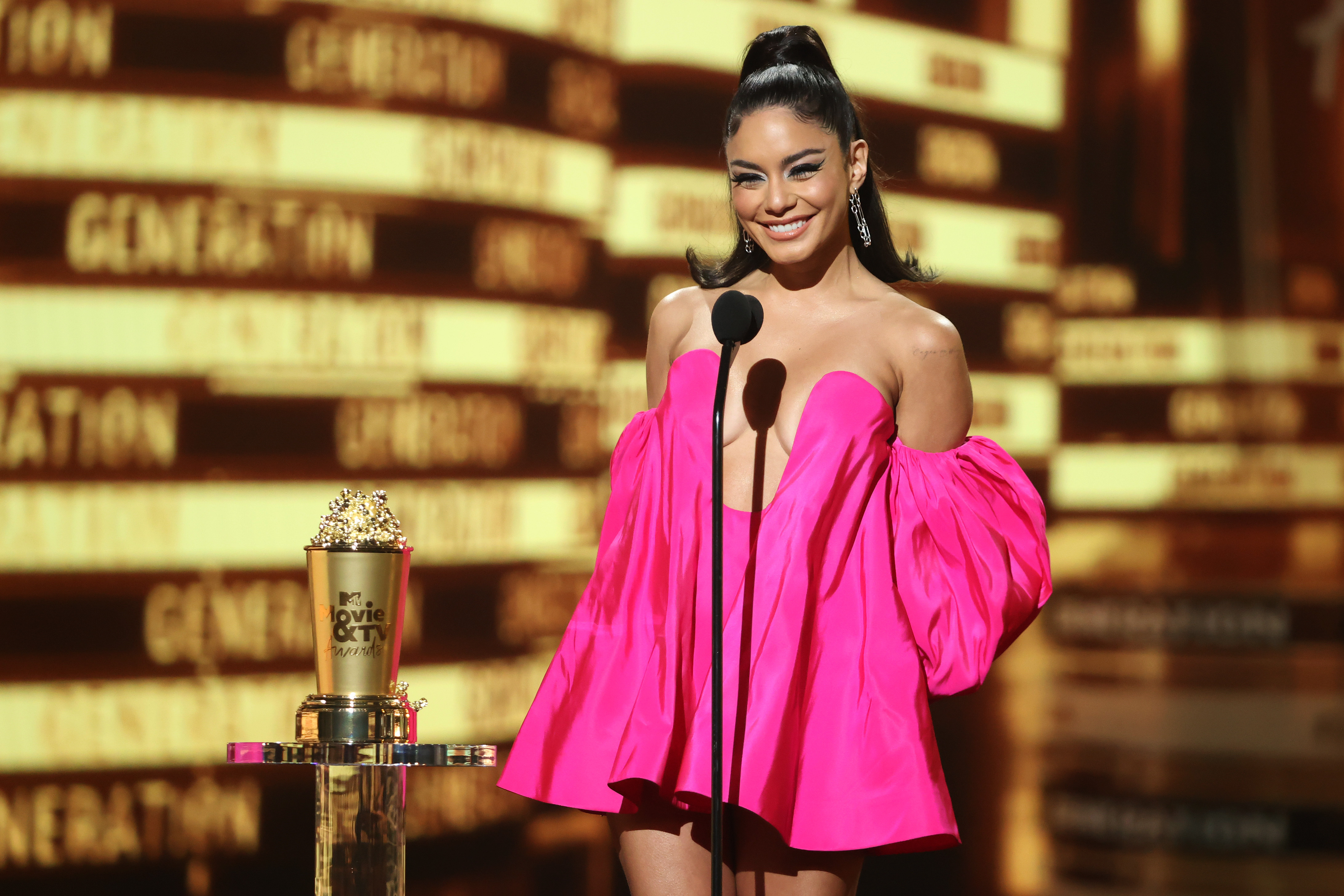 Vanessa Hudgens presenting the 2022 MTV Movie Awards. She wears a pink puff-sleeved dress