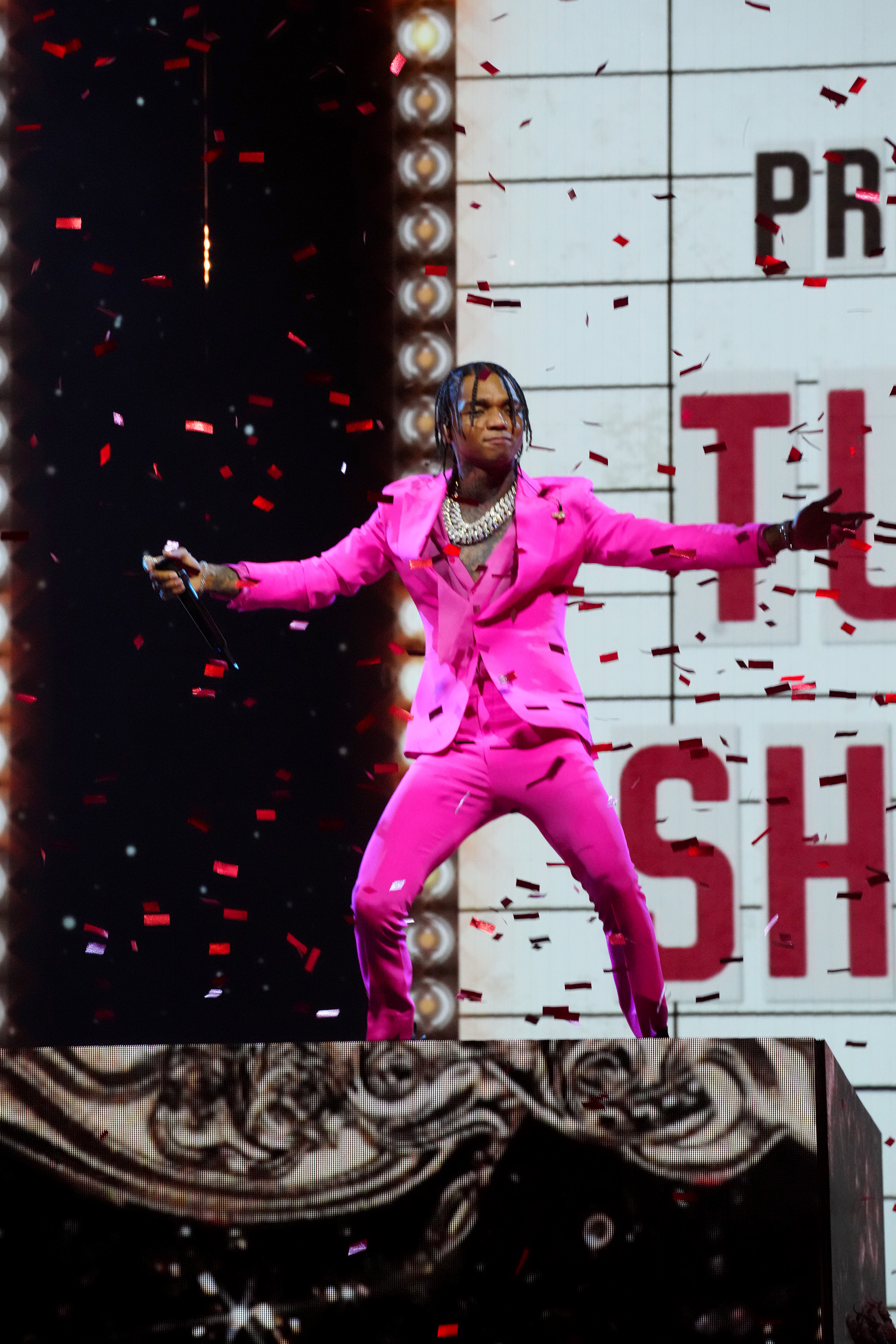 Swae Lee on stage at the MTV Movie & TV Awards in a pink pantsuit