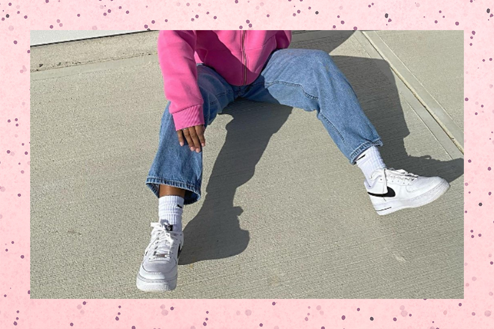 Montagem em fundo rosa com bolinhas de garota sentada no chão usando moletom rosa, calça jeans e tênis branco com meia branca