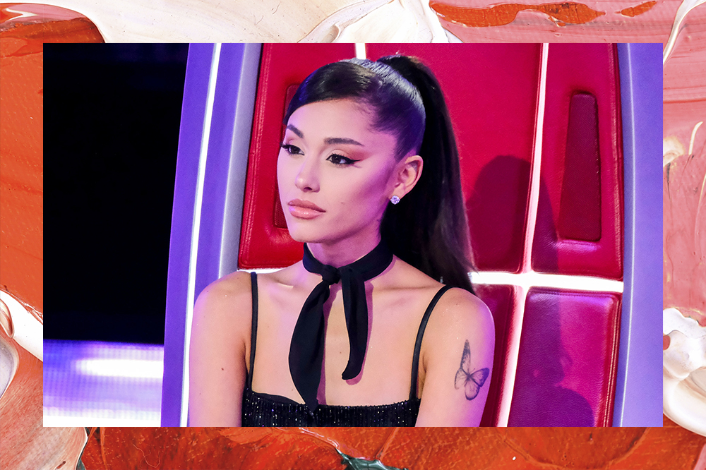 Montagem em fundo vermelho e rosa de Ariana Grande com expressão facial séria sentada em cadeira do The Voice