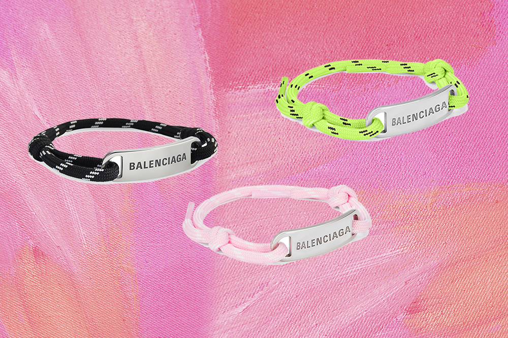 Montagem em fundo rosa com três pulseiras da Balenciaga feitas de cadarço nas cores preto, verde neon e rosa claro