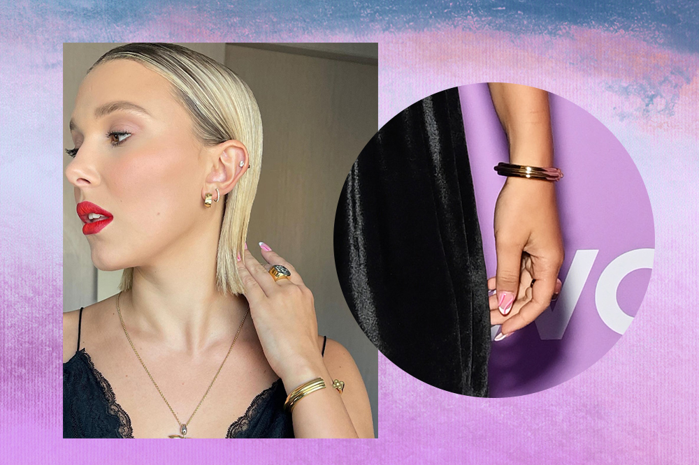 millie-bobby-brown-unha-francesinha Montagem em fundo degradê azul e lilás com foto à esquerda de Millie Bobby Brown olhando para o lado, com a mão no cabelo e usando batom vermelho. À direita, foto das unhas dela com francesinha branca com linhas rosas.