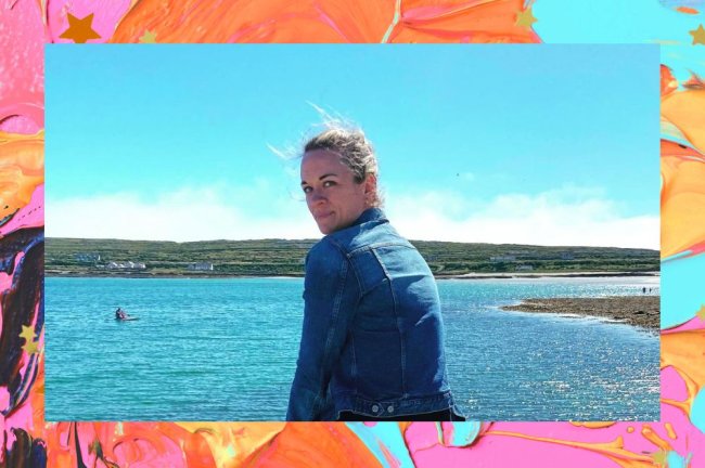 Tessa Bailey olhando para trás enquanto posa para foto com uma paisagem natural com o céu e água ao fundo; é possível ver relevos verdes ao fundo; a margem é uma textura de tintas nas cores rosa, laranja, preto, verde, amarelo e azul; estrelas amarelas e laranjas decoram a imagem