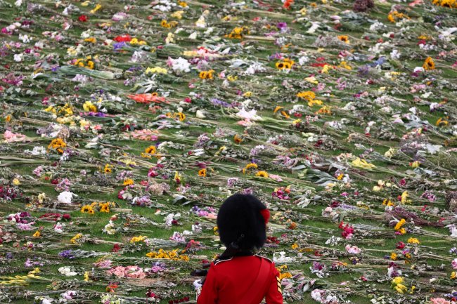 Soldado da guarda real contempla as milhares de flores deixadas para a Rainha Elizabeth II