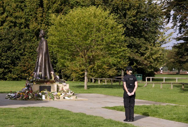 Policial contempla estátua da Rainha Elizabeth II com homenagens à monarca