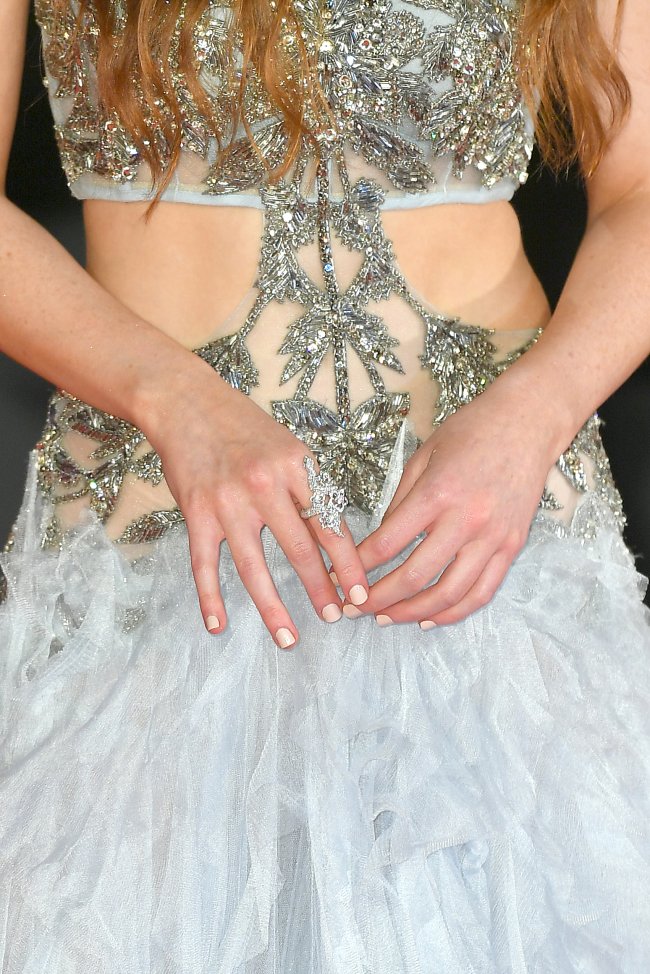 Foto close no vestido e mãos da atriz Sadie Sink no tapete vermelho da 79 edição do Festival de Veneza.