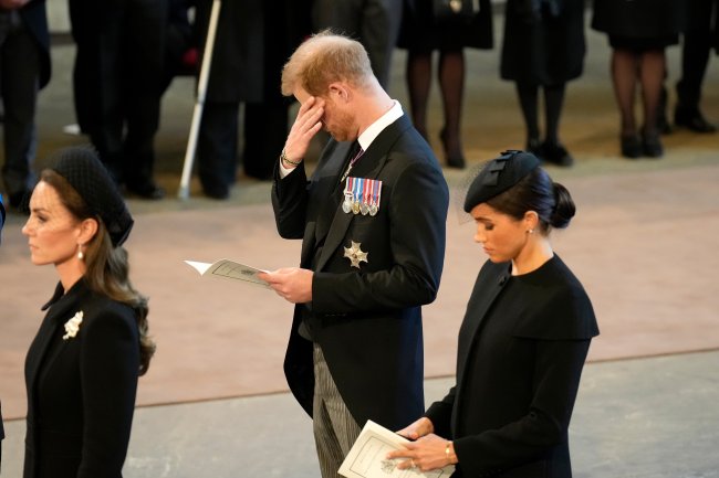 Príncipe Harry chora durante cerimonial em memória da avó, a Rainha Elizabeth II, no Palácio de Westminster. Sua esposa, Meghan Markle, está ao seu lado