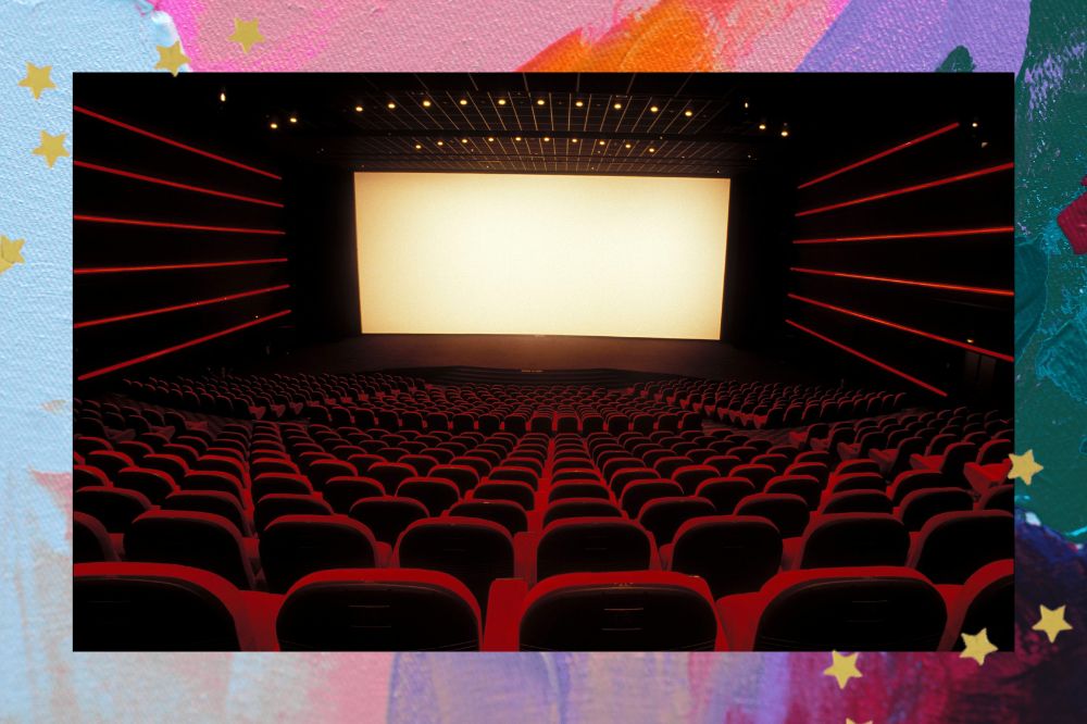 Sala de cinema vista de cima, com cadeiras vermelhas e telão