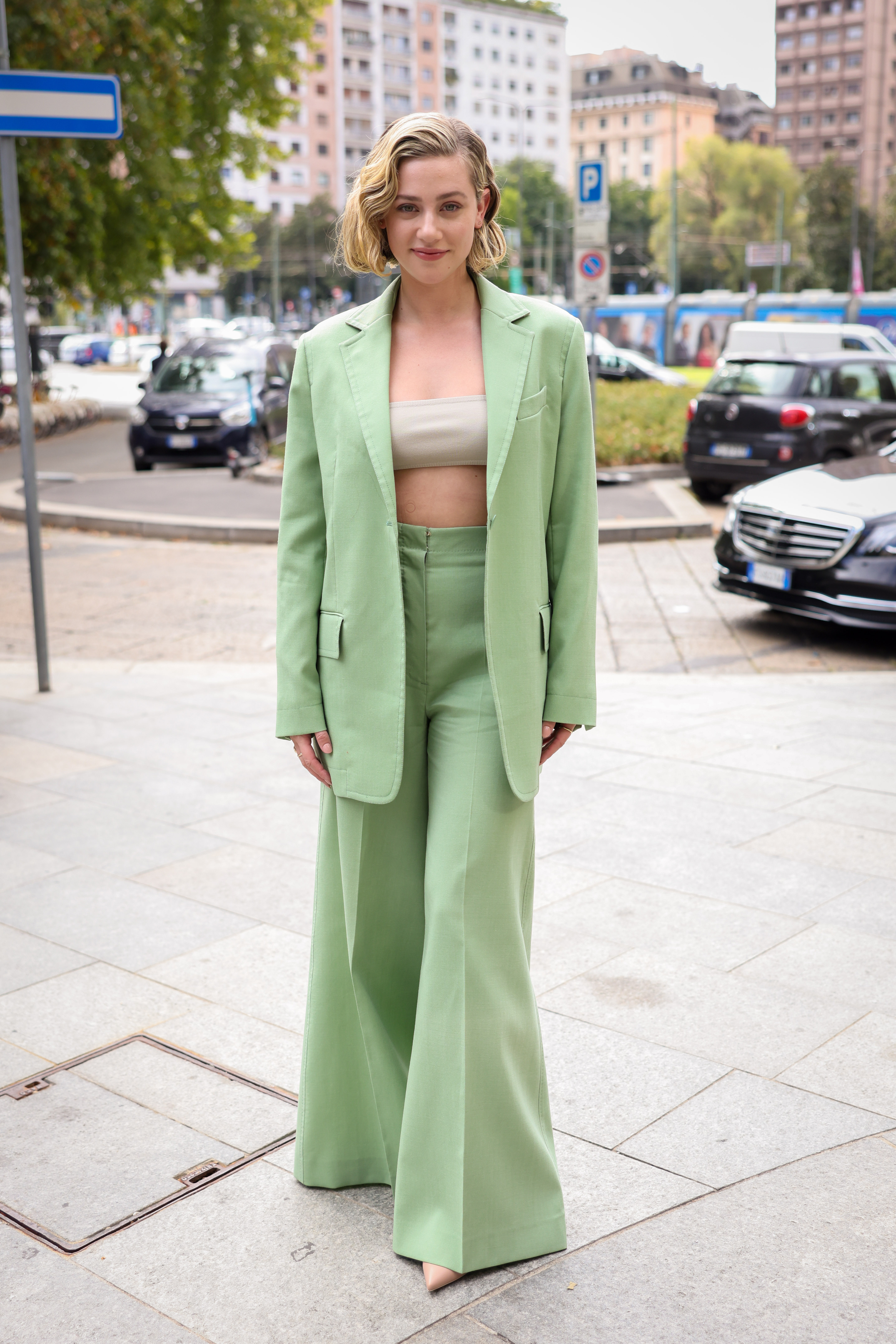 Lili Reinhart heading to Max Mara's Spring-Summer 2023 show at Milan Fashion Week wearing a pistachio green tailored outfit and sash top