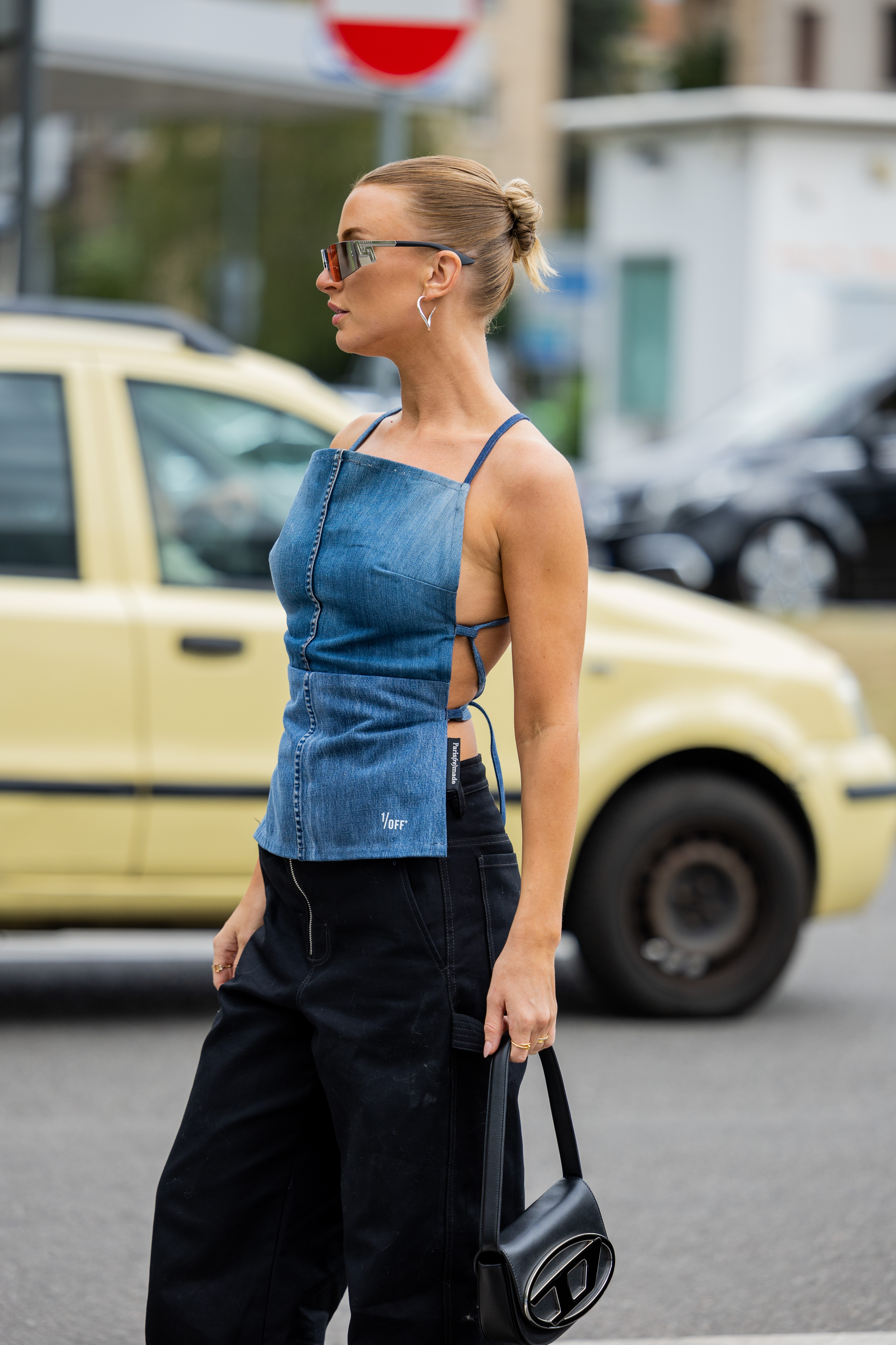 Garota usando blusa jeans e calça preta no street style da semana de moda de Milão
