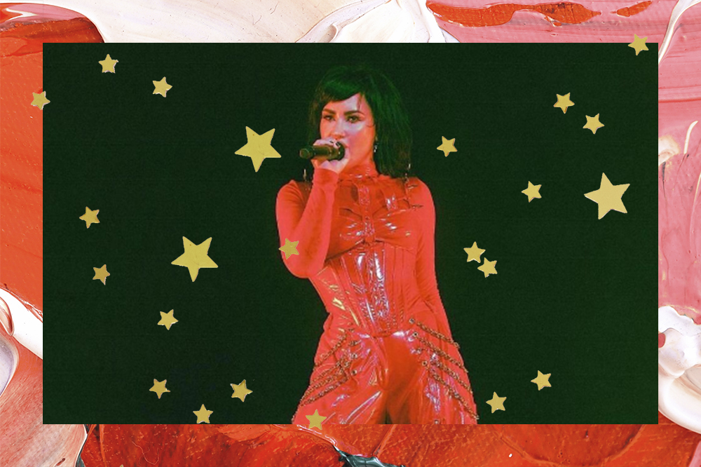 Montagem em fundo vermelho e rosa com estrelinhas douradas de foto de Demi Lovato fazendo show com look todo vermelho feito por marca brasileira