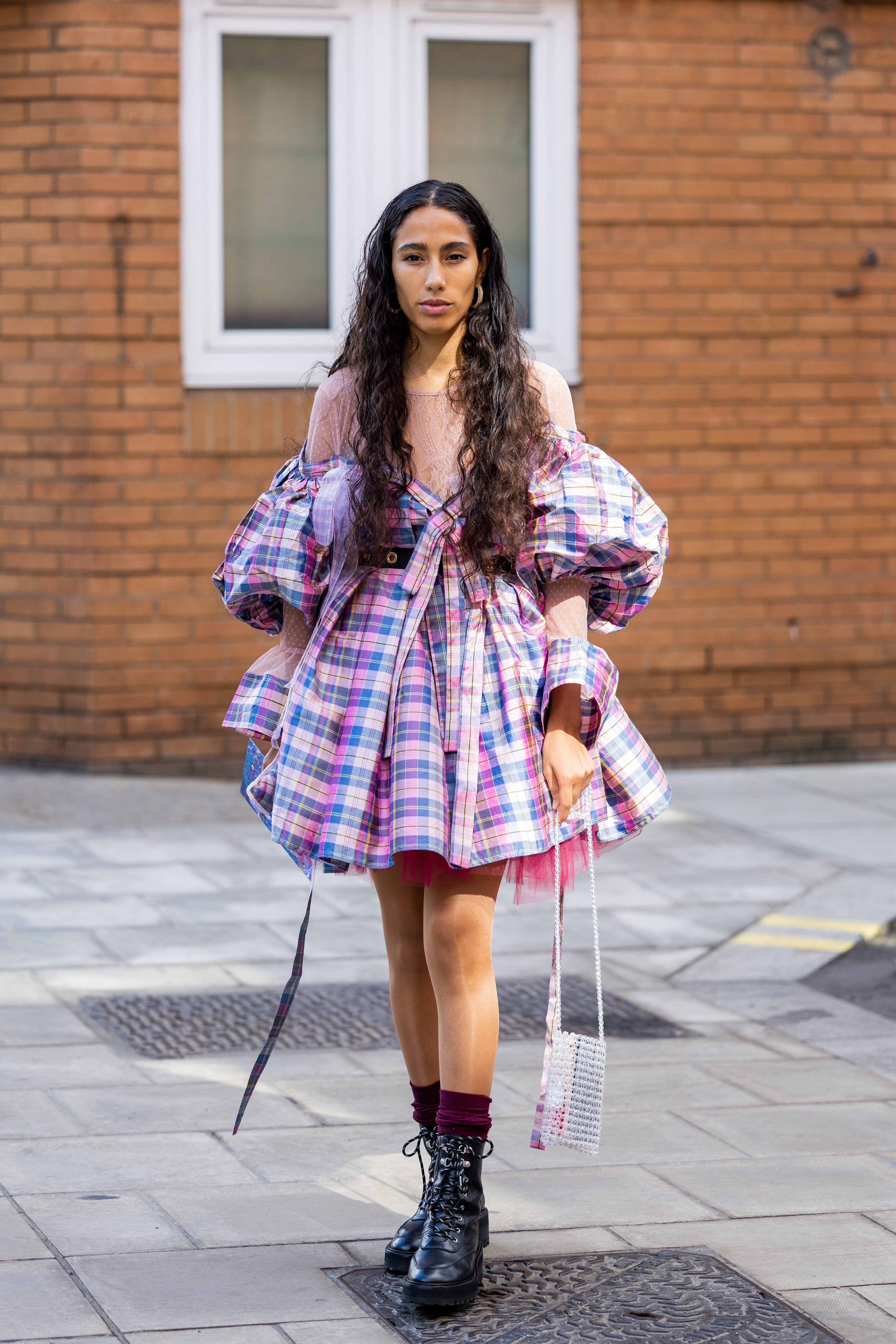 Garota usando vestido xadrez rosa e azul com coturno preto no street style da semana de moda de Londres