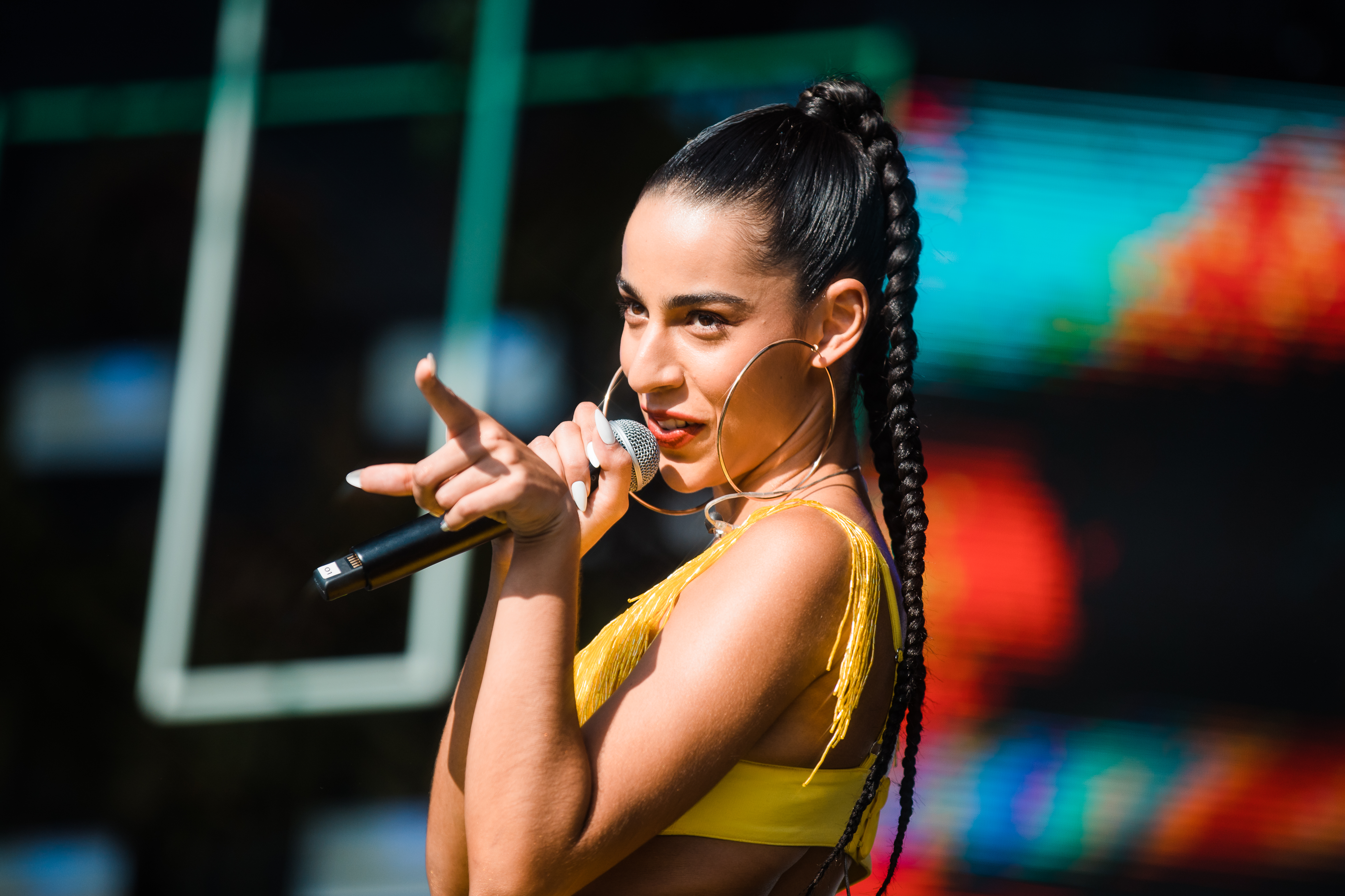 Marina Sena cantando em palco e apontando dedo para platéia