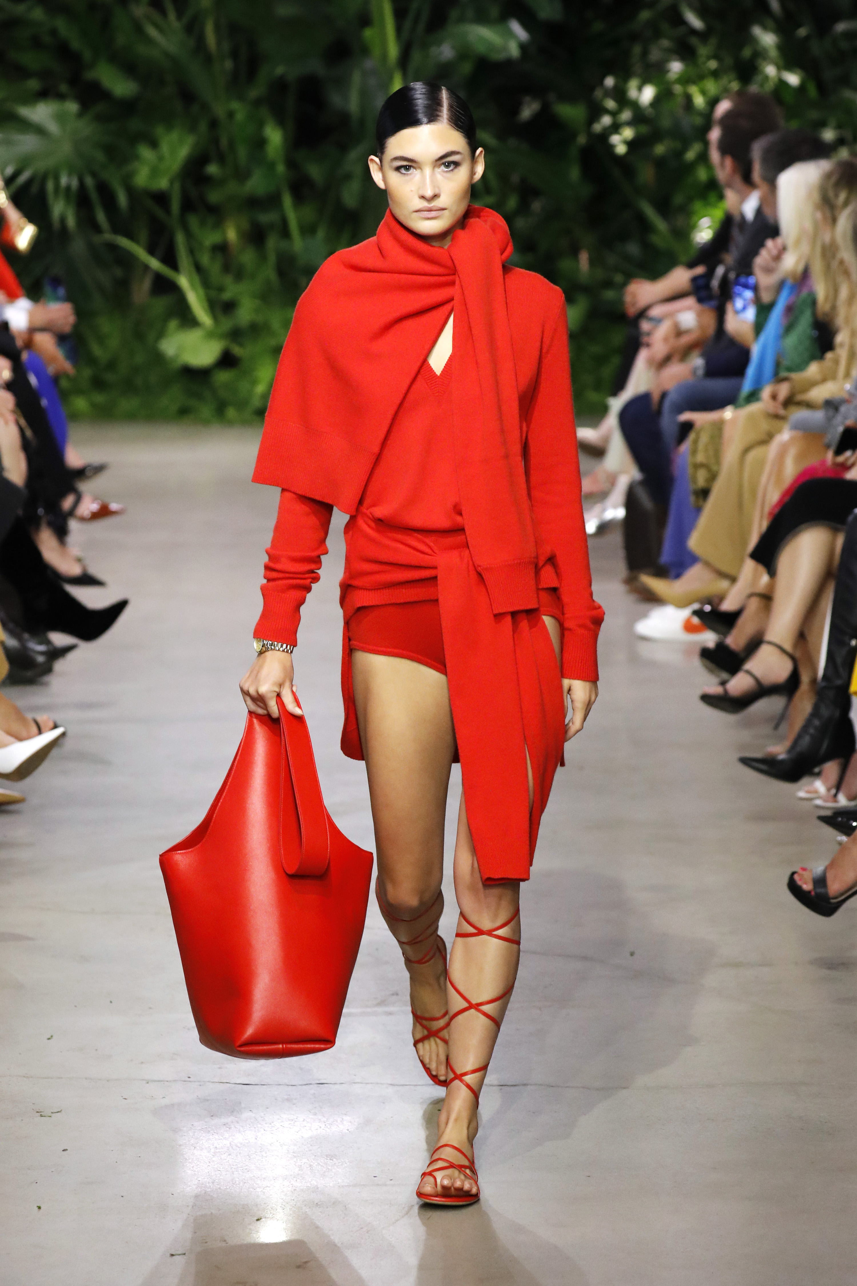 Modelo usando look todo vermelho e carregando maxibolsa em desfile de primavera-verão 2023 da Michael Kors na semana de moda de Nova York