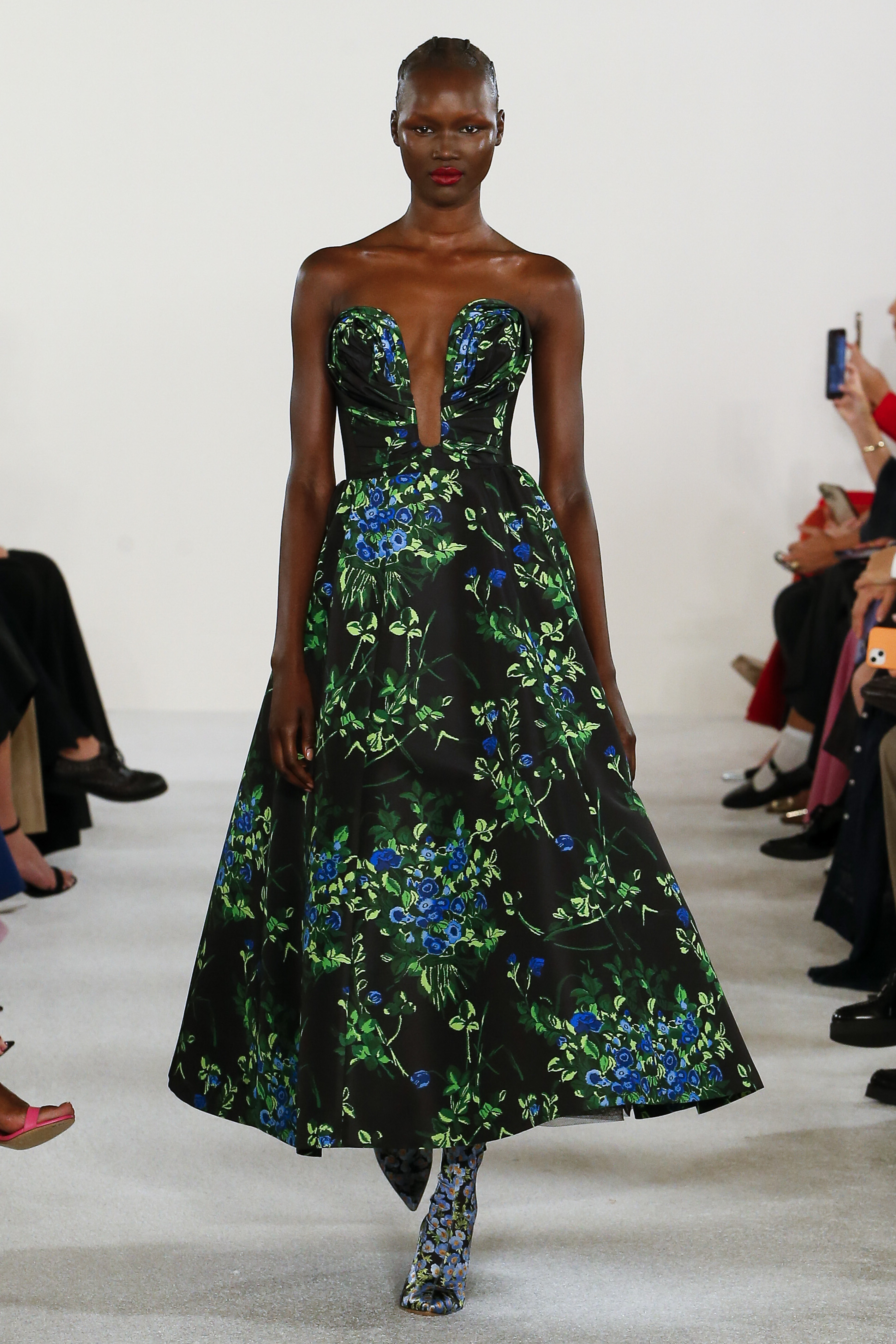 Desfile de primavera-verão 2023 da Carolina Herrera na semana de moda de Nova York. Modelo usando vestido longo e sem alças com estampa floral de fundo escuro