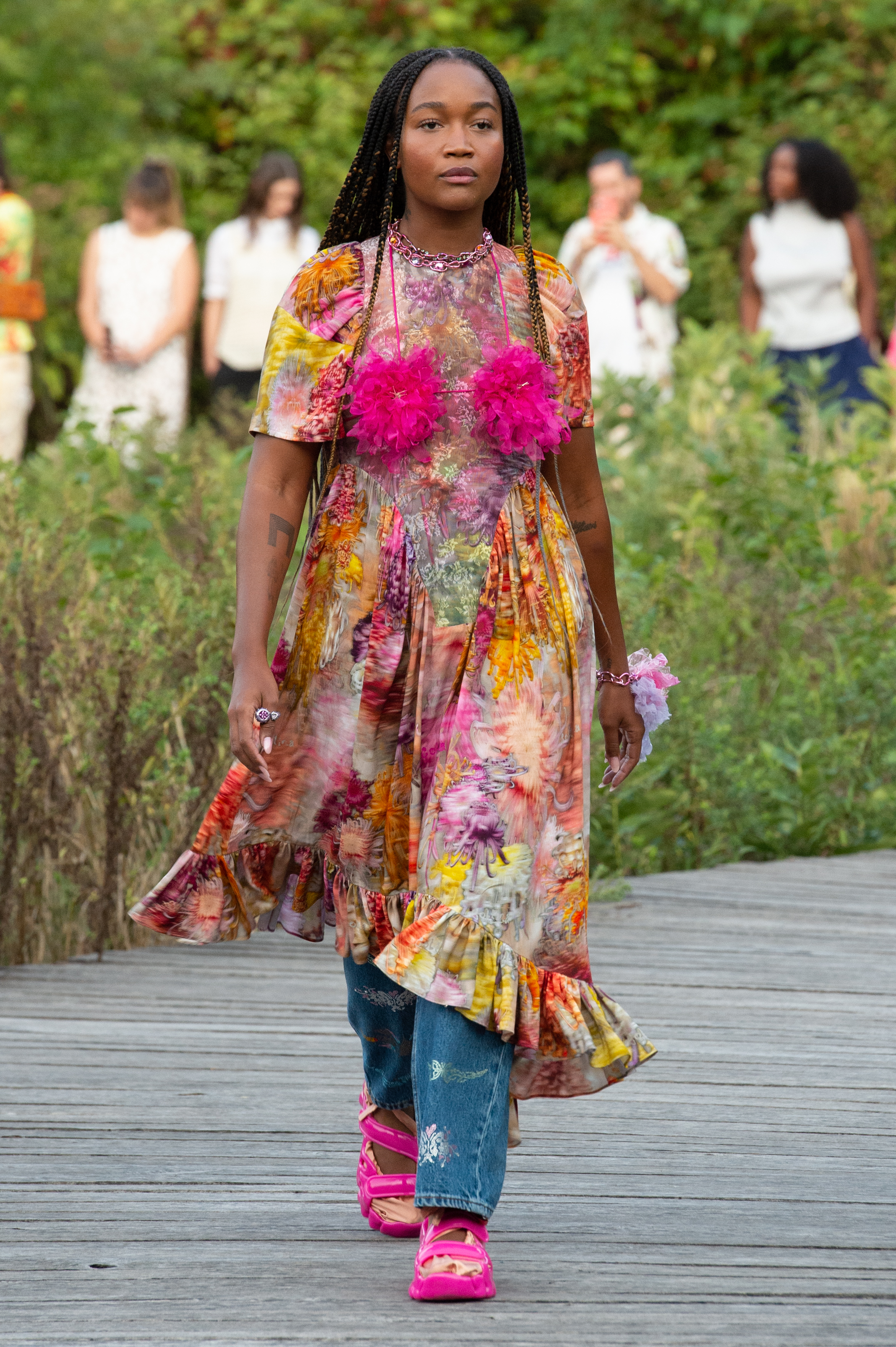 Desfile de primavera-verão 2023 da Collina Strada na semana de moda de Nova York. Modelo usando vestido floral por cima de calça jeans