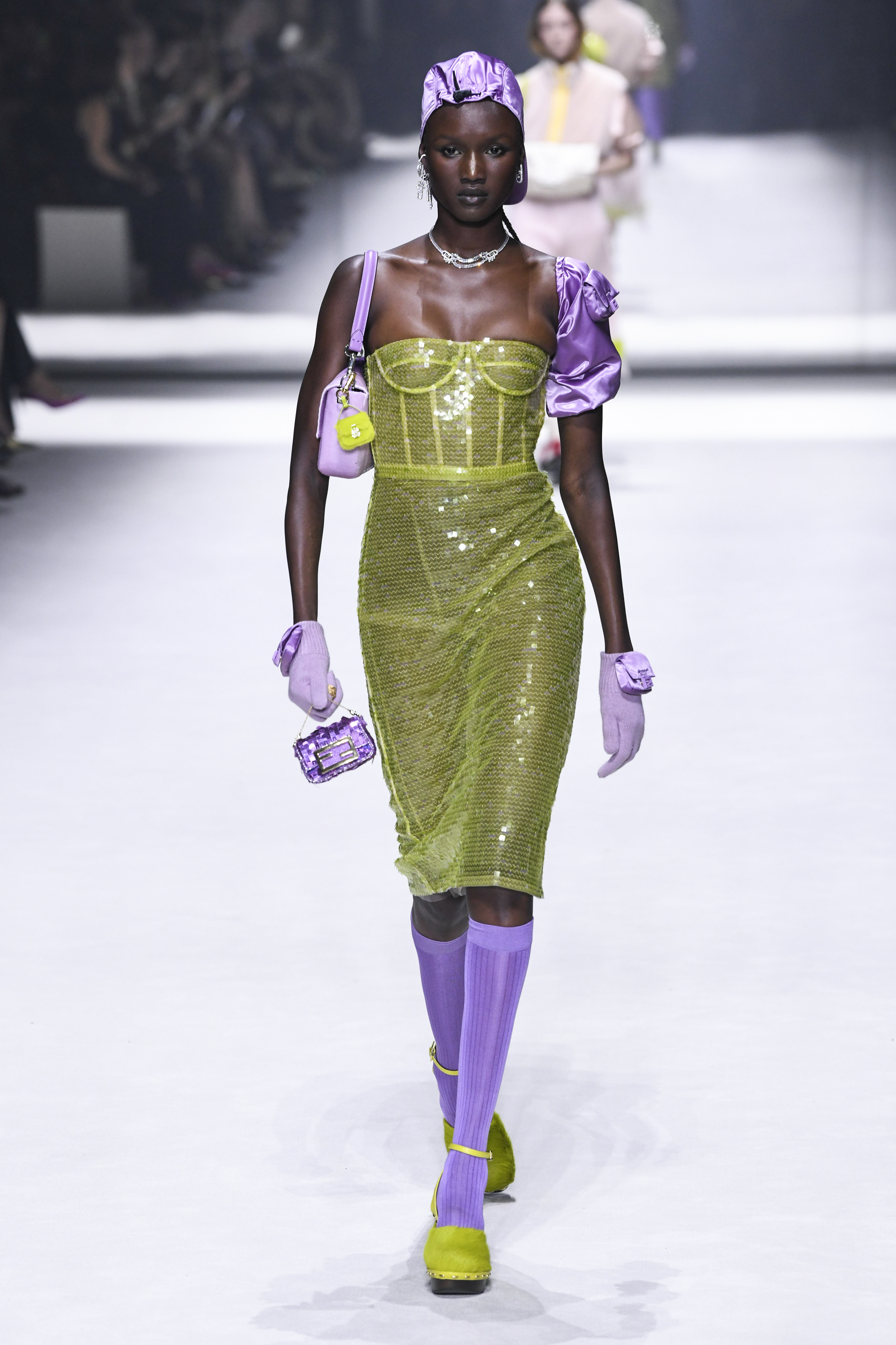 Desfile de primavera-verão 2023 da Fendi na semana de moda de Nova York. Modelo usando vestido de brilhos verde e luvas, meias e bolsa lilás
