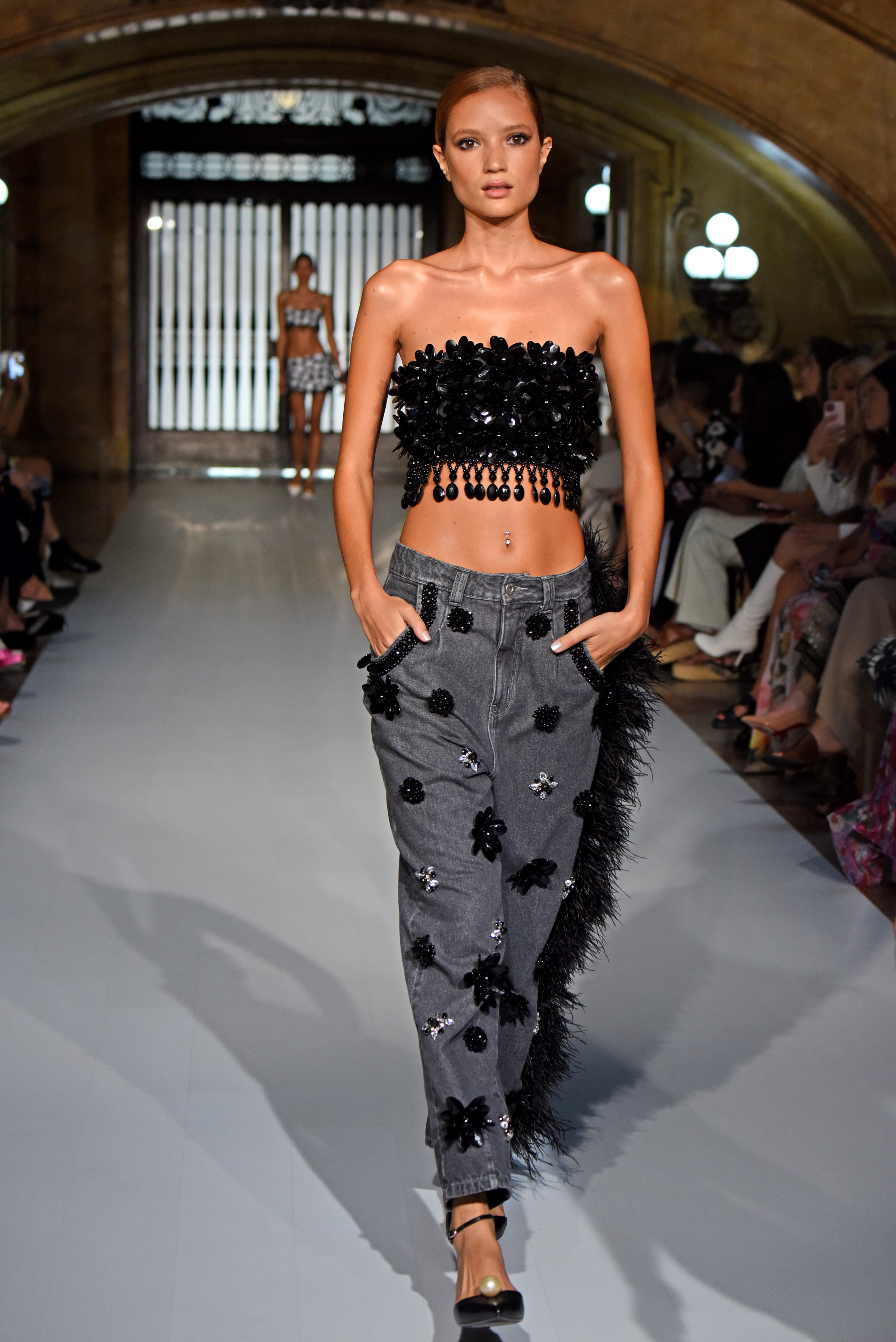 Desfile de primavera-verão 2023 da PatBo na semana de moda de Nova York. Modelo usando top preto e calça jeans escura com aplicações em preto