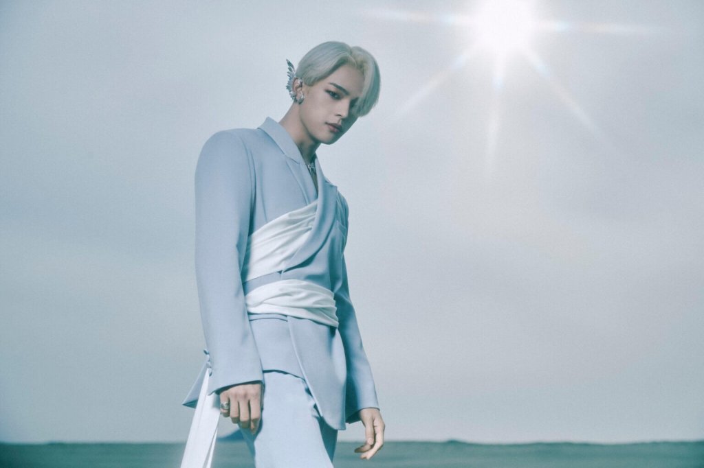 Woojin posando para foto ao ar livre com roupa prata