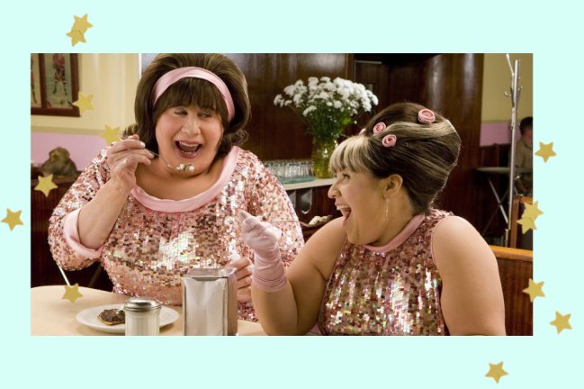 Hairspray scene with two characters looking at each other and laughing