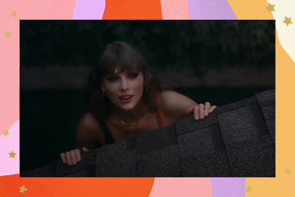 Taylor Swift no clipe de Anti-Hero; ela está se apoiando em um telhando enquanto olha para cima e sorri levemente