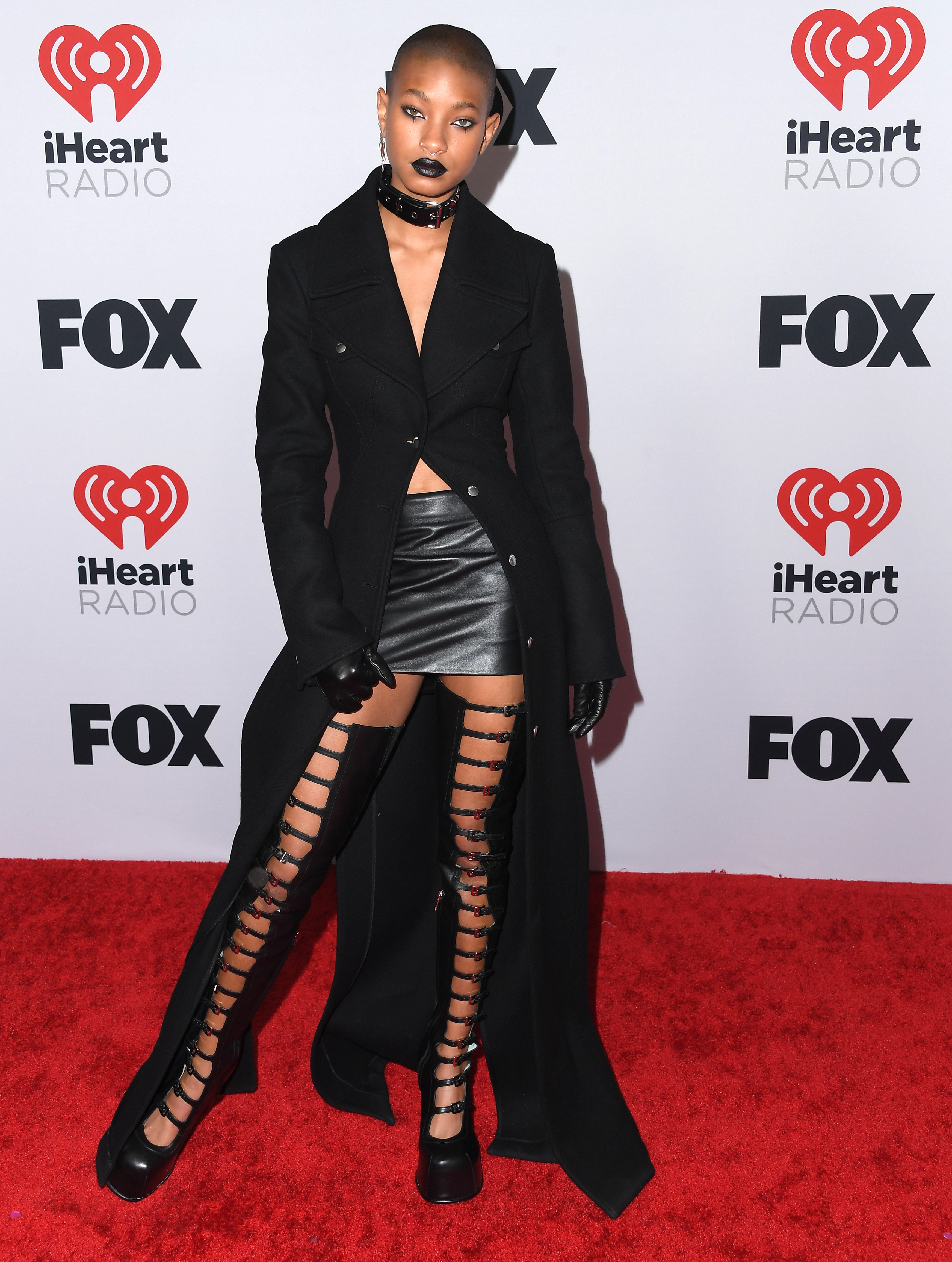 Willow Smith no iHeartRadio Music Awards em março de 2022 usando look todo preto com bota até a coxa