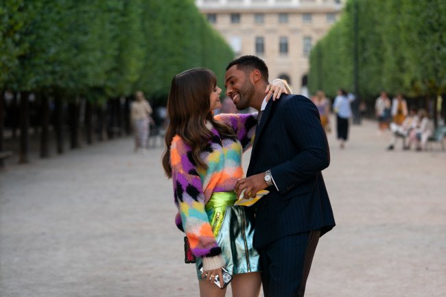 EIP_301_Unit_01333R Lily Collins e Lucien Laviscount como Emily e Alfie em cena de Emily em Paris; eles estão abraçados na rua enquanto sorriem com os rostos próximos um do outro