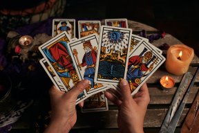 Uma mão segura algumas cartas de tarot