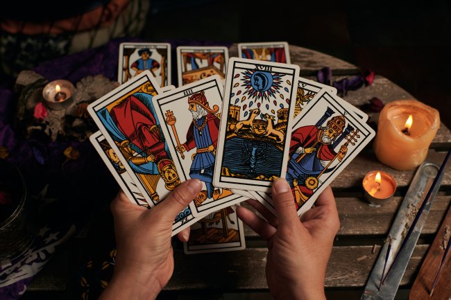 Uma mão segura algumas cartas de tarot