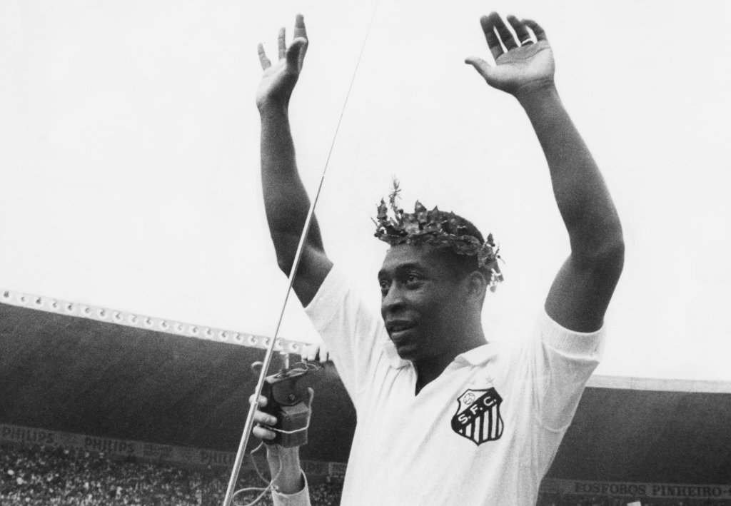 Pelé comemorando com coroa e blusa do Santos