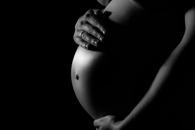 Foto preto e branco de uma barriga de grávida