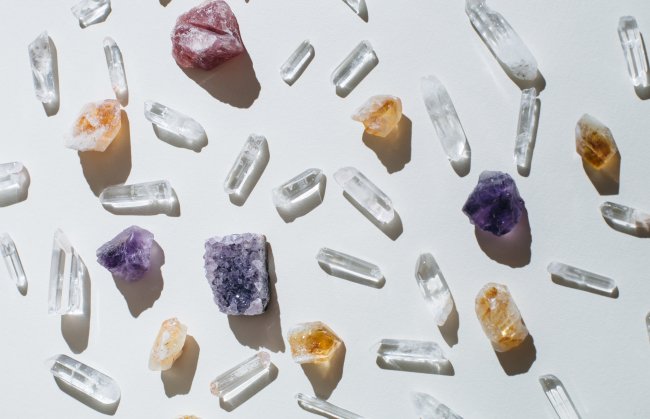 Foto de cristais e pedras coloridas espalhados sobre uma mesa branca