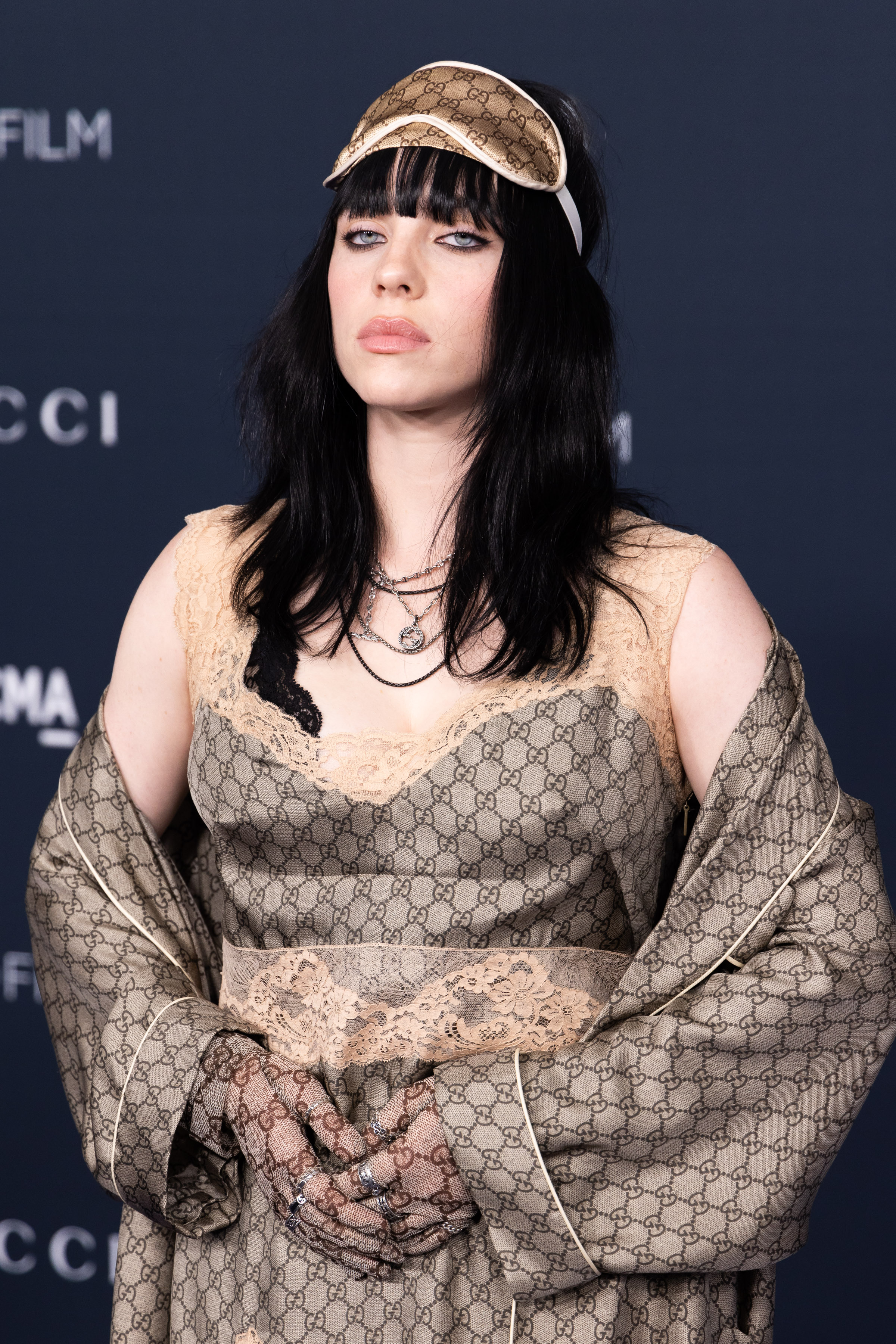Billie Eilish no 11th Annual LACMA Art+Film Gala em 2022 usando look da Gucci com faixa de dormir na cabeça e expressão facial séria