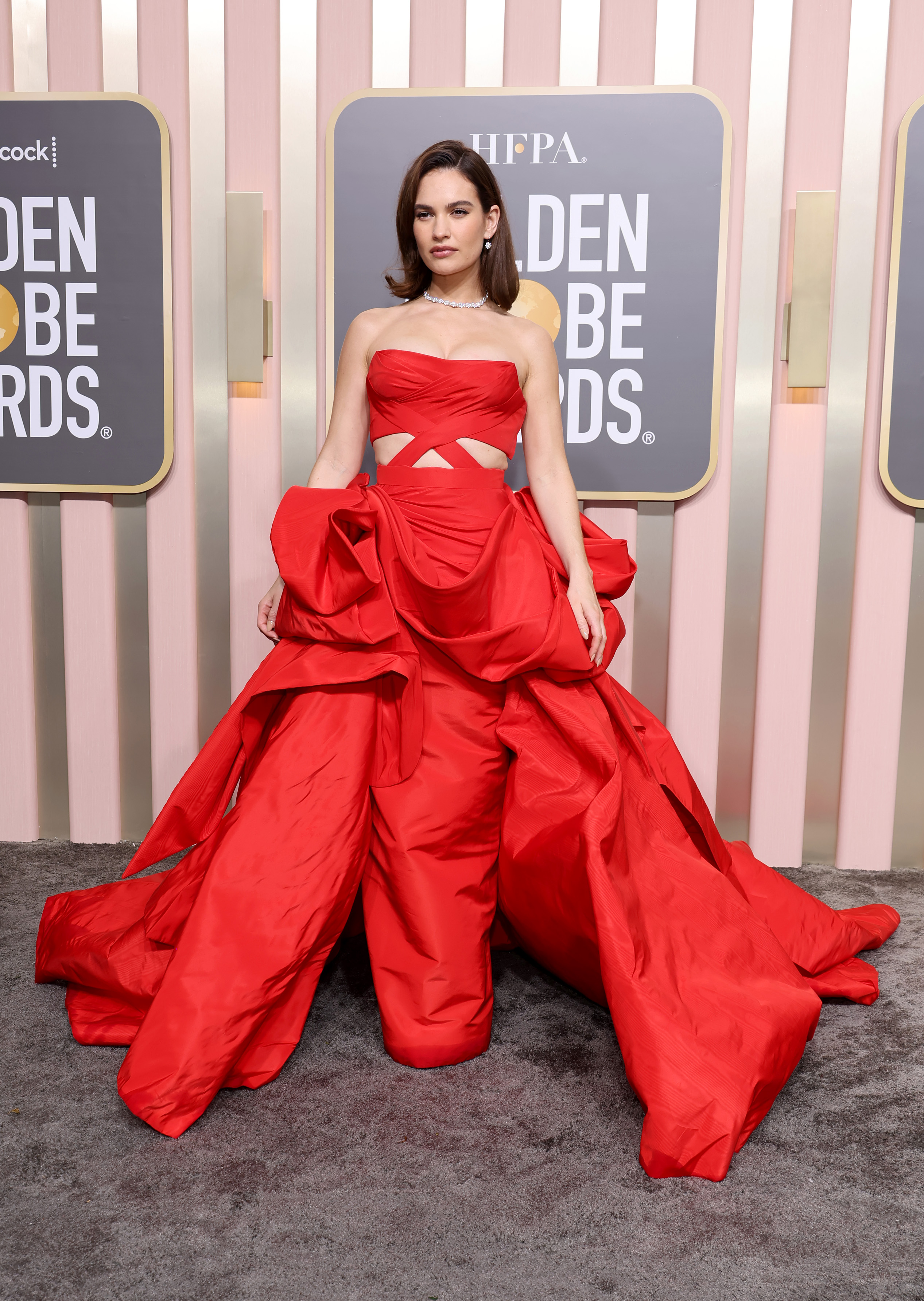 Lily James com vestido vermelho volumoso no Globo de Ouro 2023