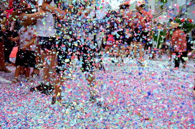 Pessoas curtem o Canaval em meio a confetes coloridos