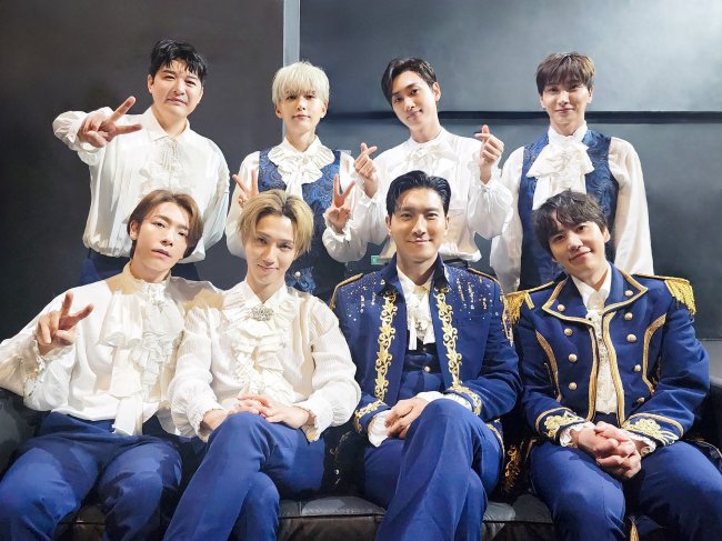 Integrantes do grupo Super Junior posando para foto sorrindo levemente