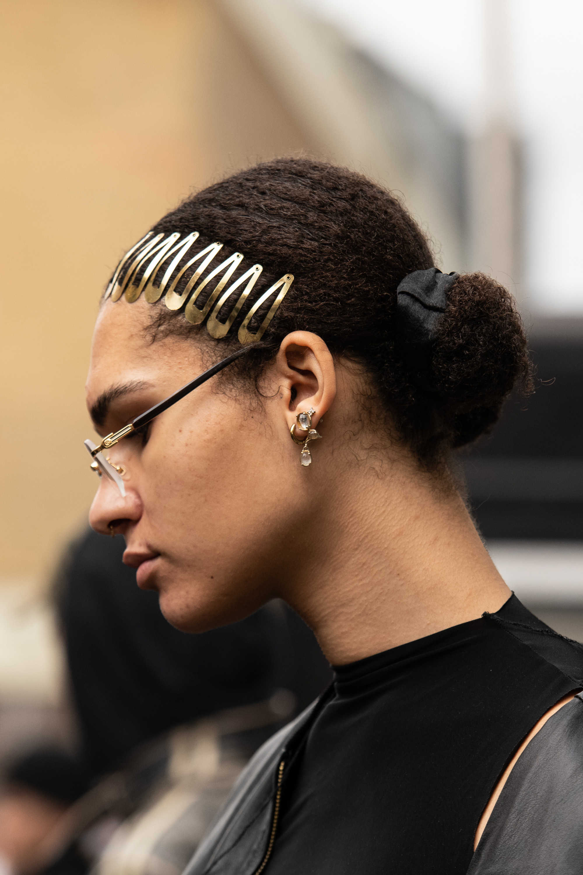 Pessoa usando presilhas metalizadas douradas no cabelo em look do street style da semana de moda de Londres