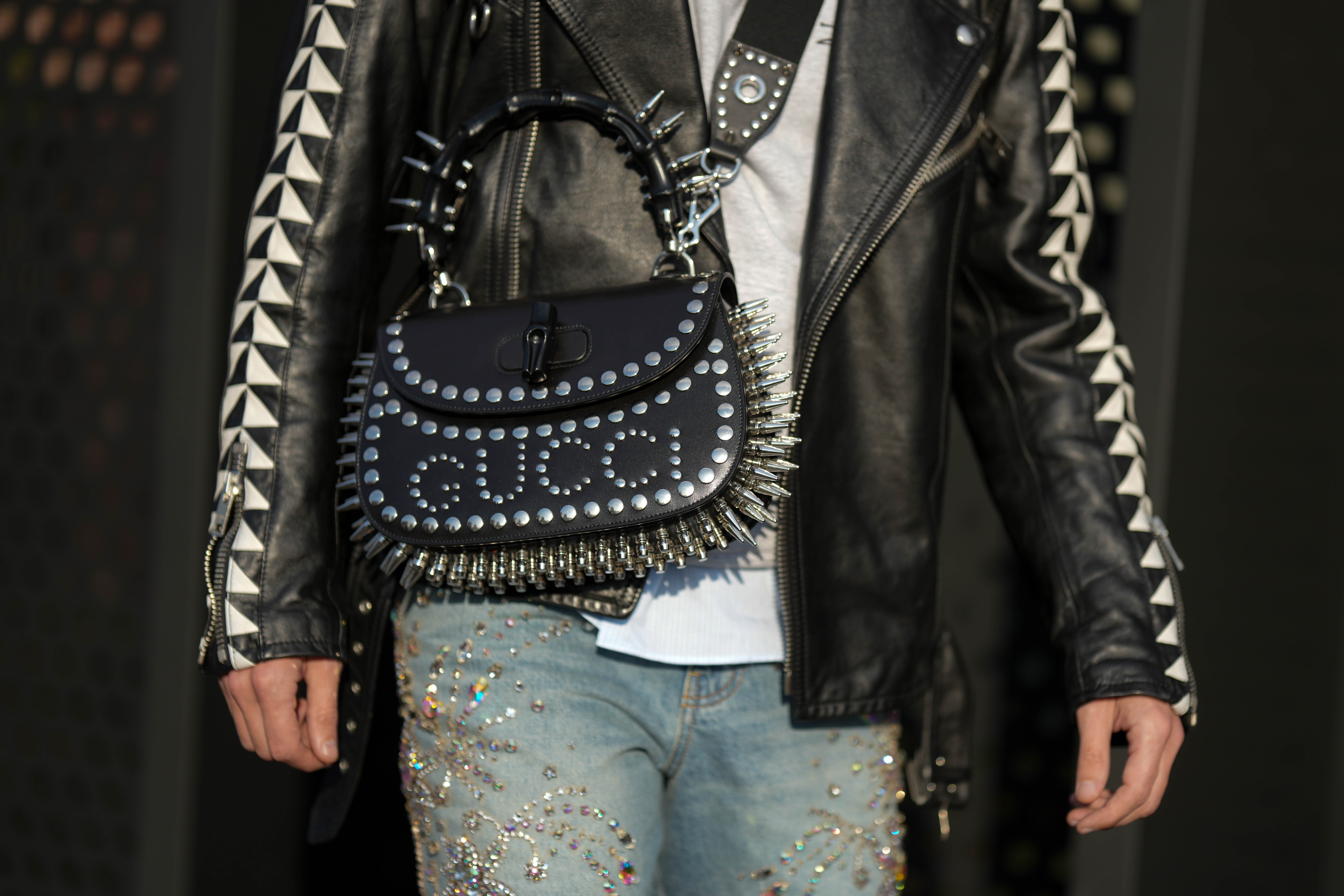 Look com bolsa da Gucci preta com spikes na semana de moda masculina de Milão em janeiro de 2023