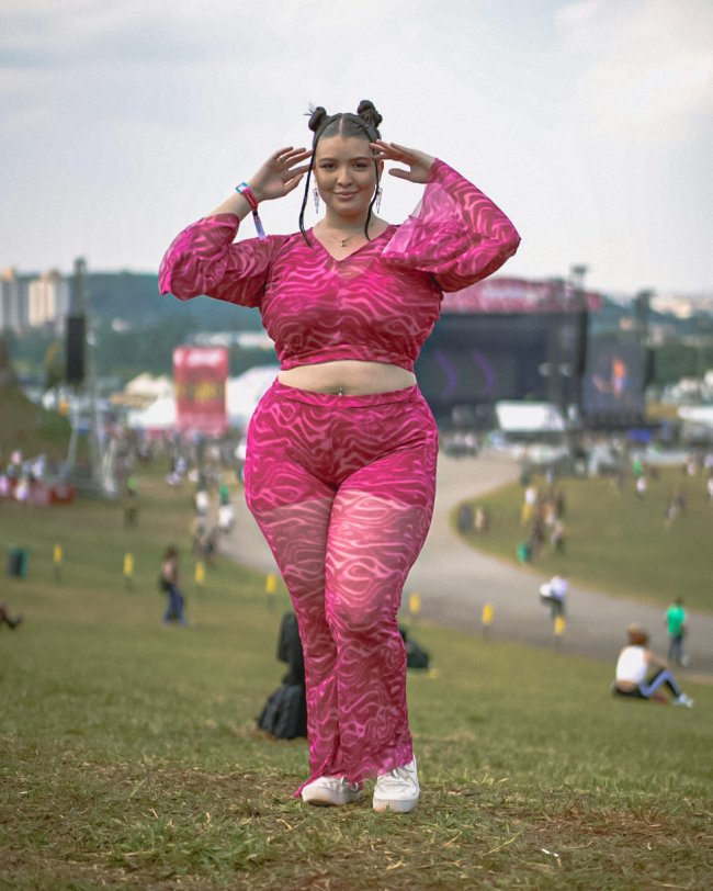 Foto de uma mulher no Lollapalooza 2023 com um look rosa com estampa psicodélica.