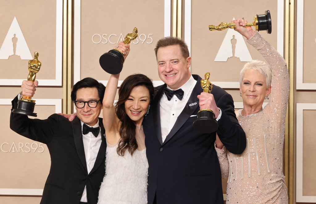 Ke Huy Quan, Michelle Yeoh, Brendan Fraser e Jamie Lee Curtis no Oscar 2023; eles estão sorrindo e posando para foto enquanto seguram estatuetas de seus prêmios no evento
