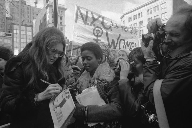 A célebre jornalista e ativista feminista Gloria Steinem dá autógrafos durante passeata em NY