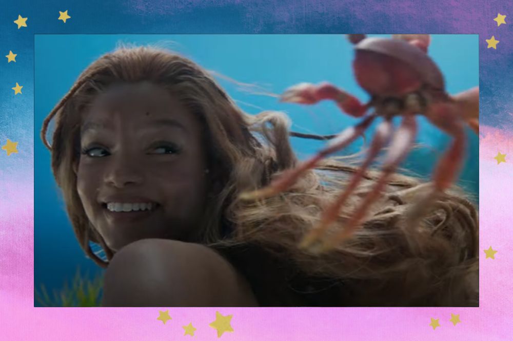Halle Bailey como Ariel em cena de A Pequena Sereia; ela está sorrindo enquanto olha para Sebastian, o caranguejo, no mar; a margem é uma textura nas cores azul, branco e rosa com estrelas amarelas como decoração