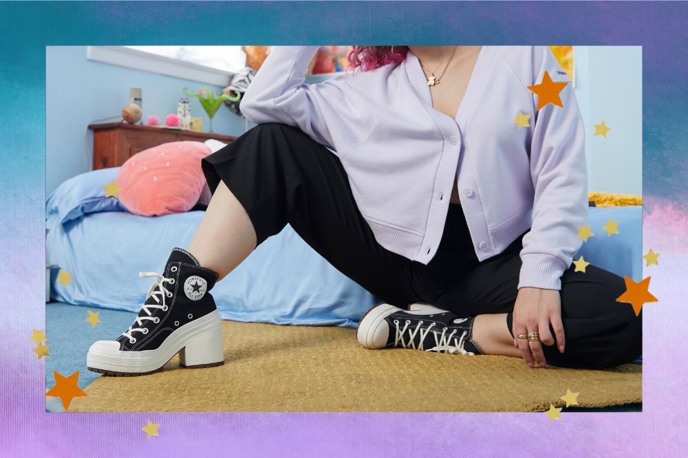 Garota usando o tênis de salto Chuck 70 De Luxe Heel da Converse com legging e camisa. Ela está em quarto e o fundo da montagem é degradê azul e lilás com estrelinhas douradas