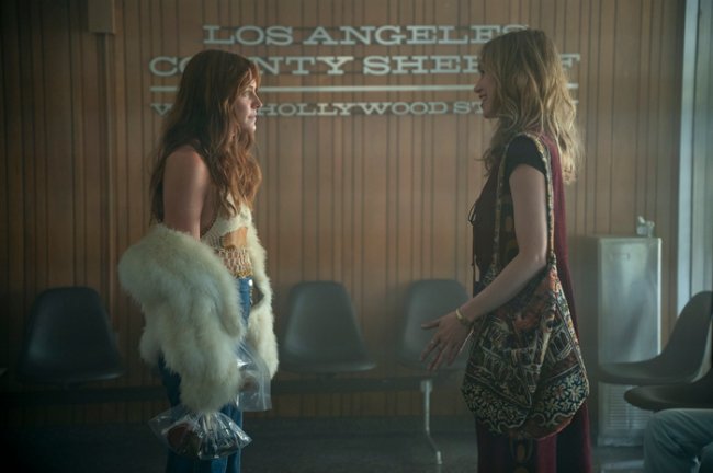 casaco-de-pelo-daisy-jones-and-the-six Foto de uma cena da série Daisy Jones and The Six das personagens Daisy e Karen.